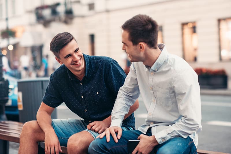 Two friends sat with each other looking happy