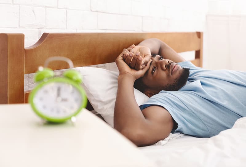 A man struggling to sleep in bed
