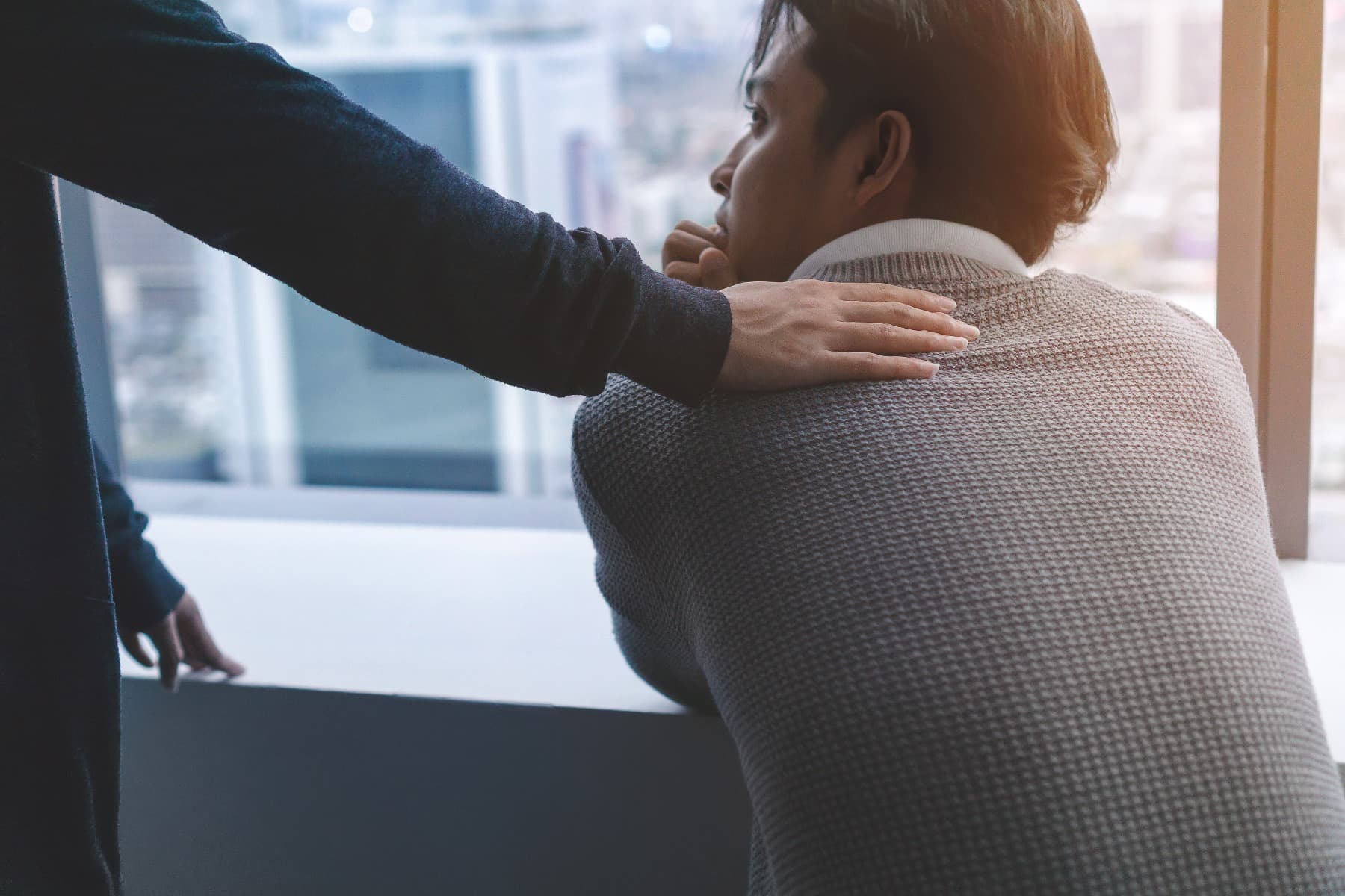A reassuring hand on a man's shoulder