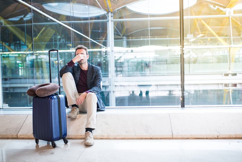 A man sat at the airport feeling tired