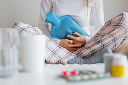 A lady holding a hot water bottle
