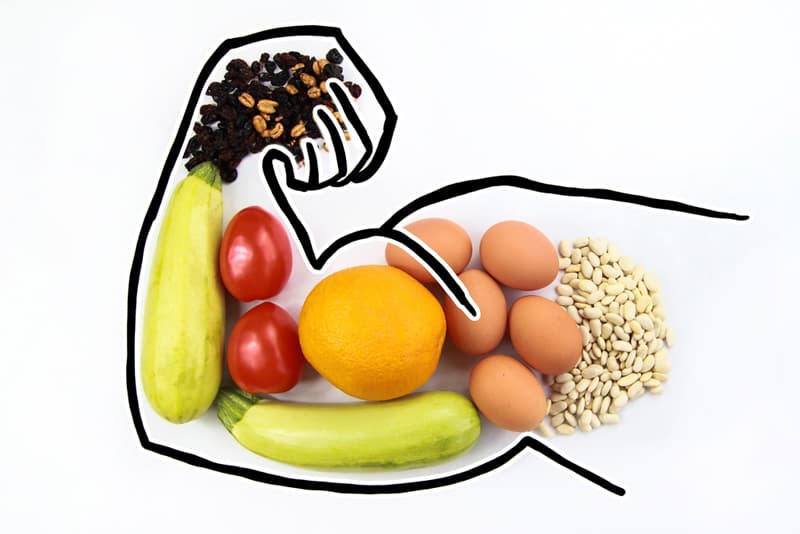 An illustration of an arm flexing it's muscles with healthy foods within it