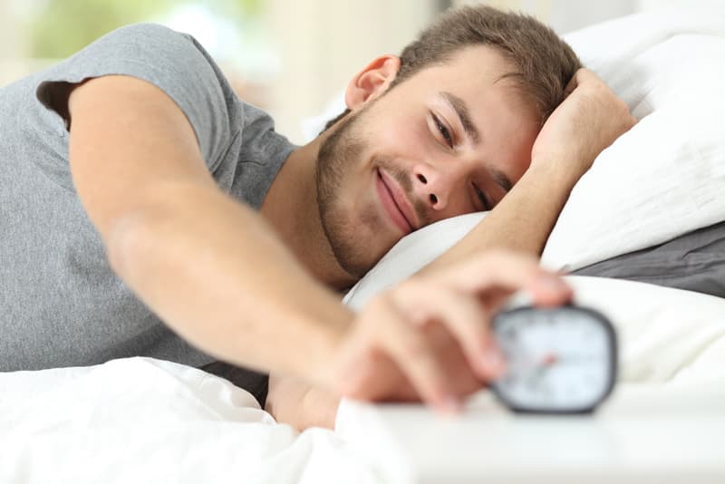 A man turning off his alarm