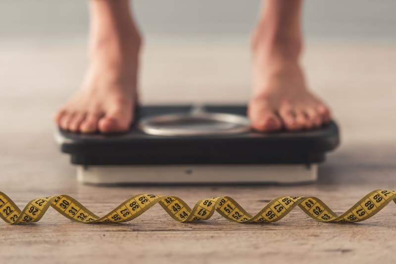 A pair of feet stood on a weighing scale to check their body weight