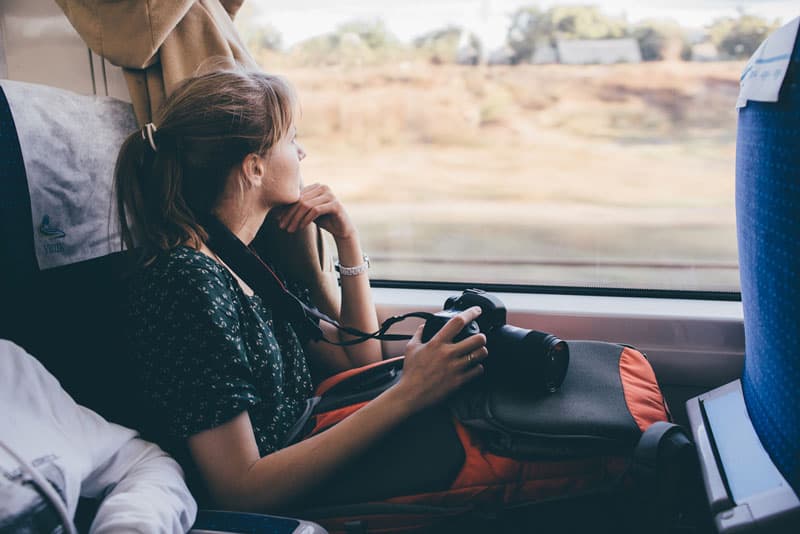 A lady staring out of a window of a moving bus