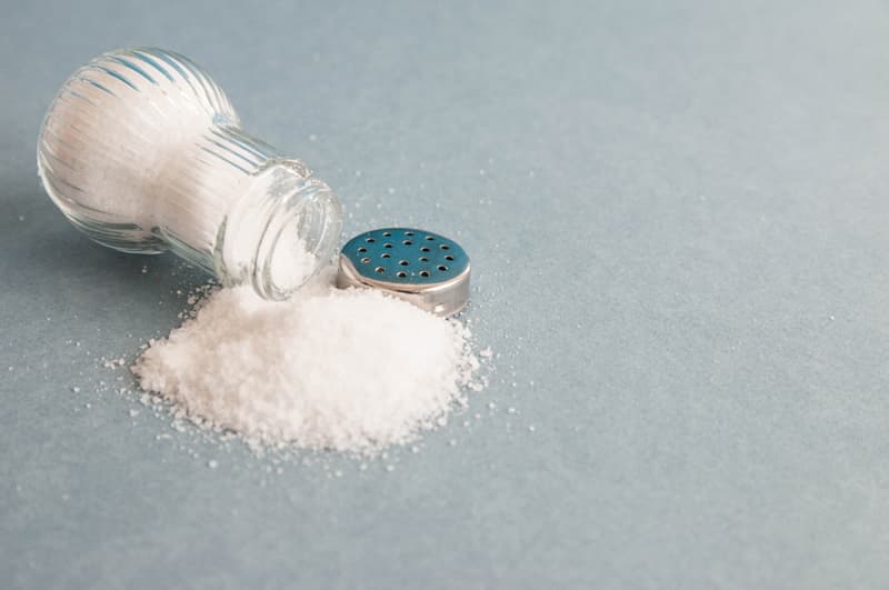 A salt shaker spilled out onto a surface