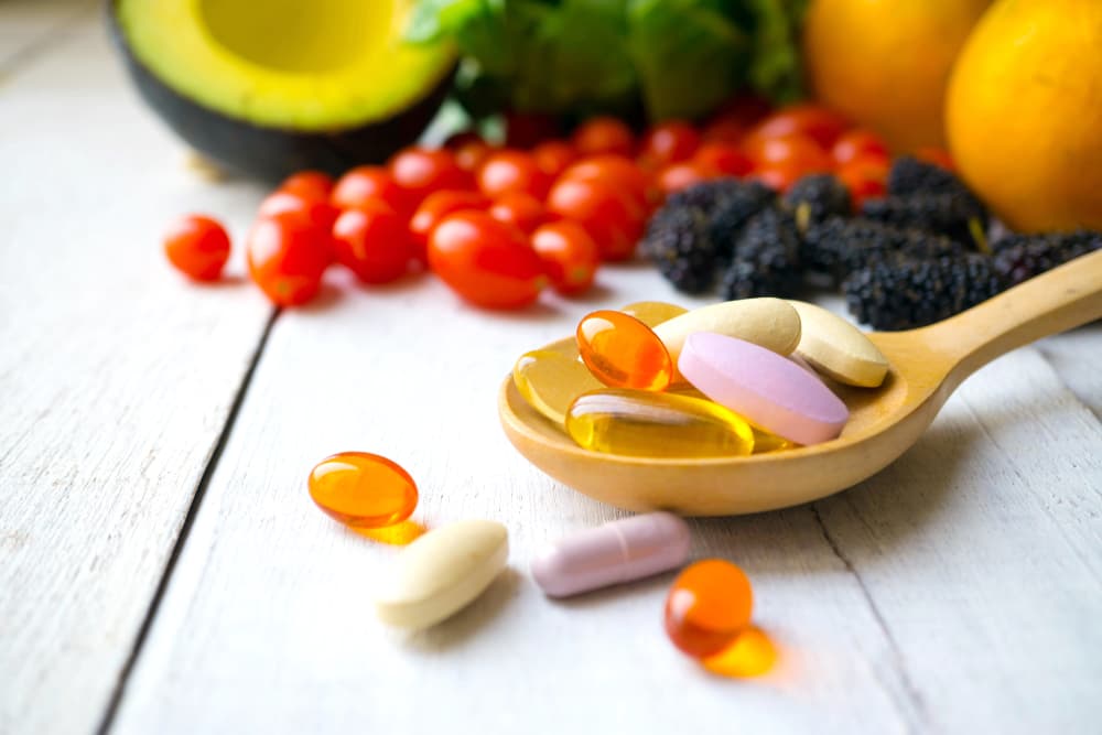 Various vitamins and supplements in a spoon