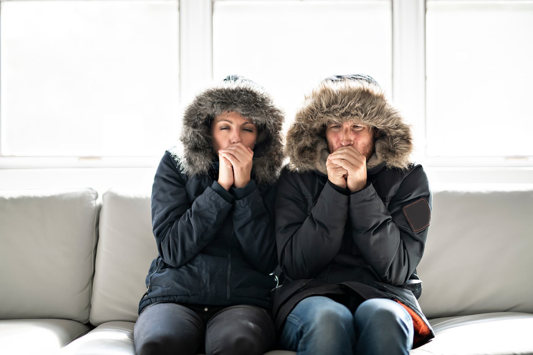 A couple sat next to each other in their winter coats