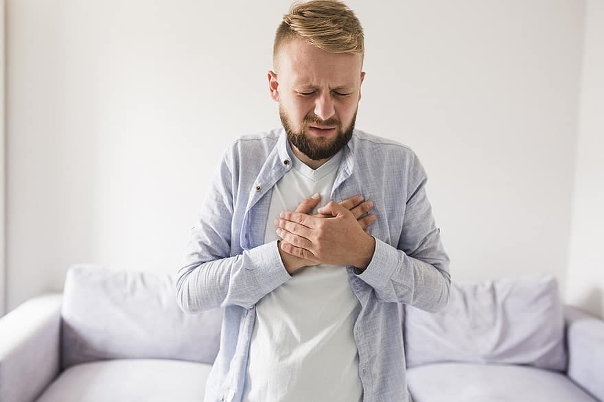A man clutching his chest in discomfort