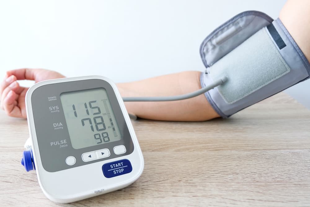 A blood pressure monitor on an arm with readings on a digital display