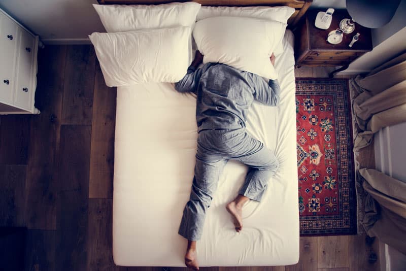 A man struggling to sleep in his bed