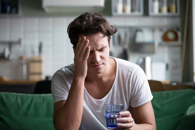 A man in discomfort due to experiencing a migraine