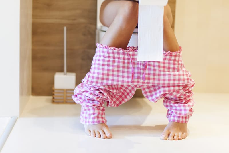 A female sat on the toilet