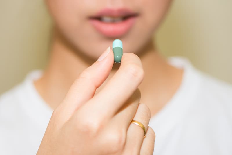 A person holding a tablet of Trimethoprim