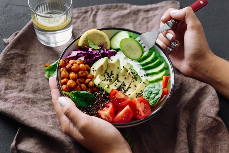 A bowl full of health food including a mix of vegetables and legumes