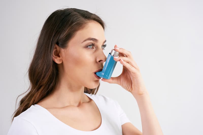 A lady using a salbutamol inhaler
