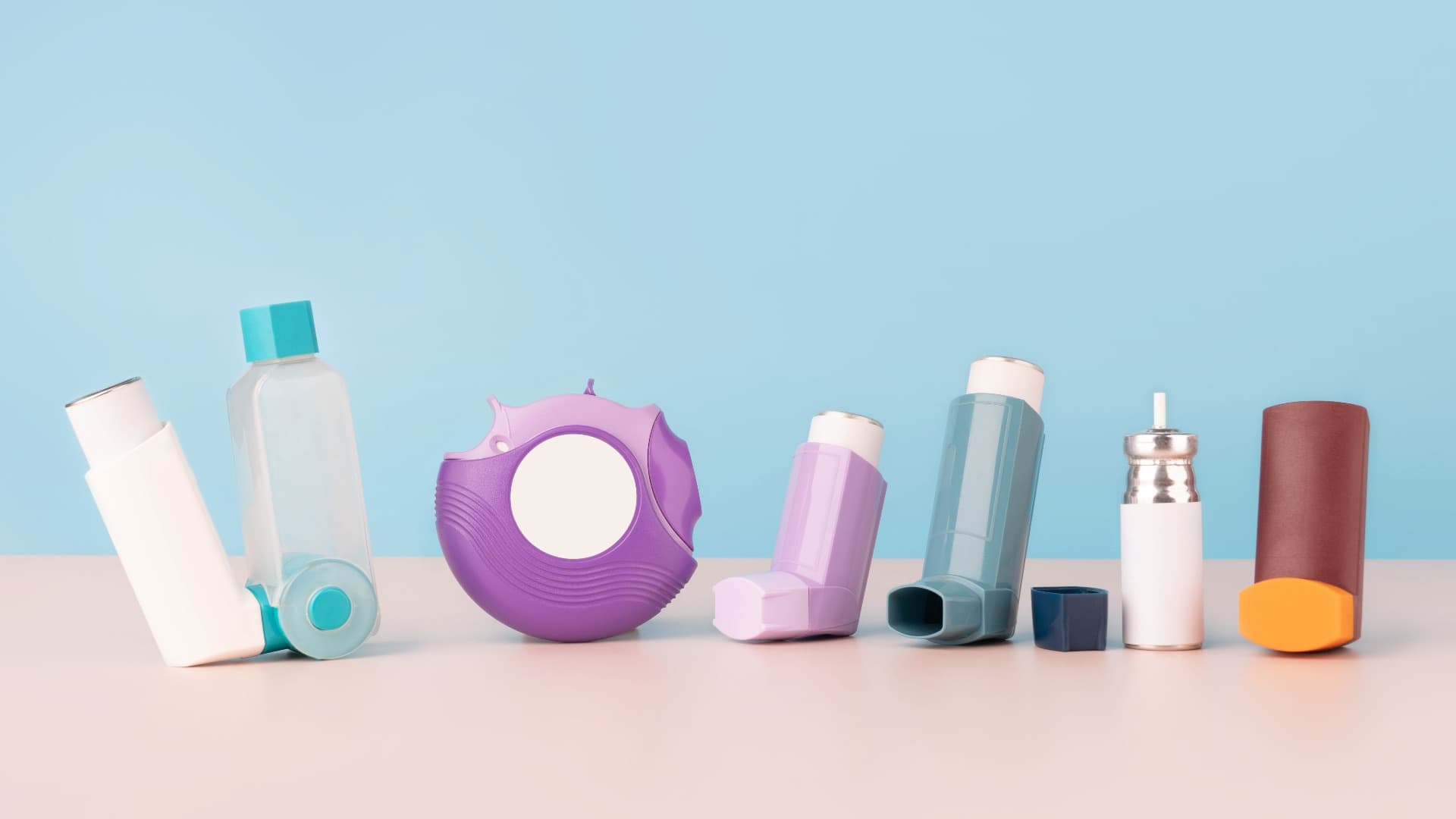 A selection of different asthma inhalers next to each other on a table