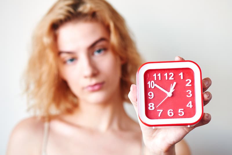A lady holding up a clock