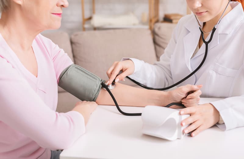 A doctor assessing a patient's high blood pressure using a blood pressure monitor