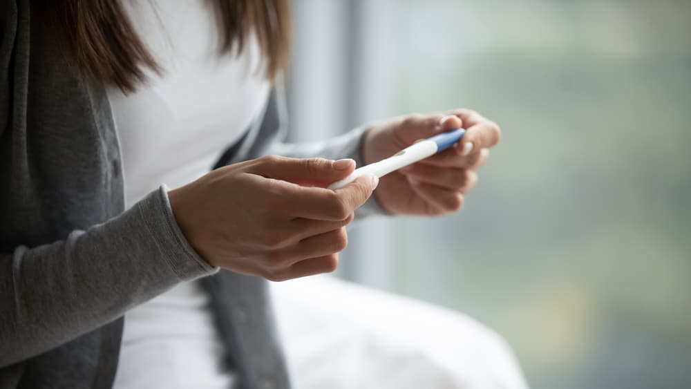 A lady looking at a pregnancy test