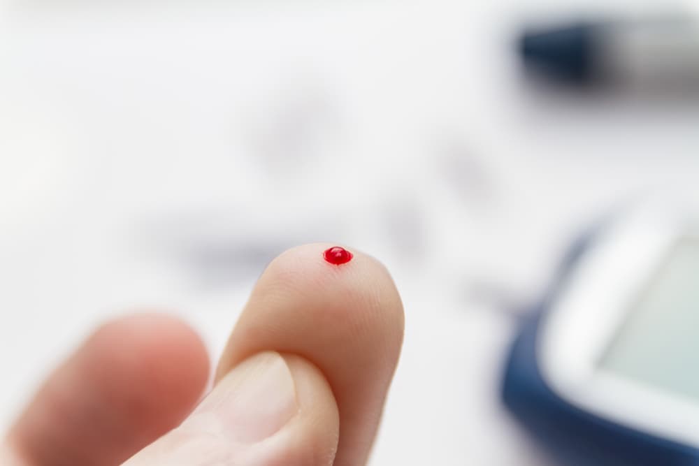 Blood on the end of a finger, following a finger prick test to check blood sugar levels