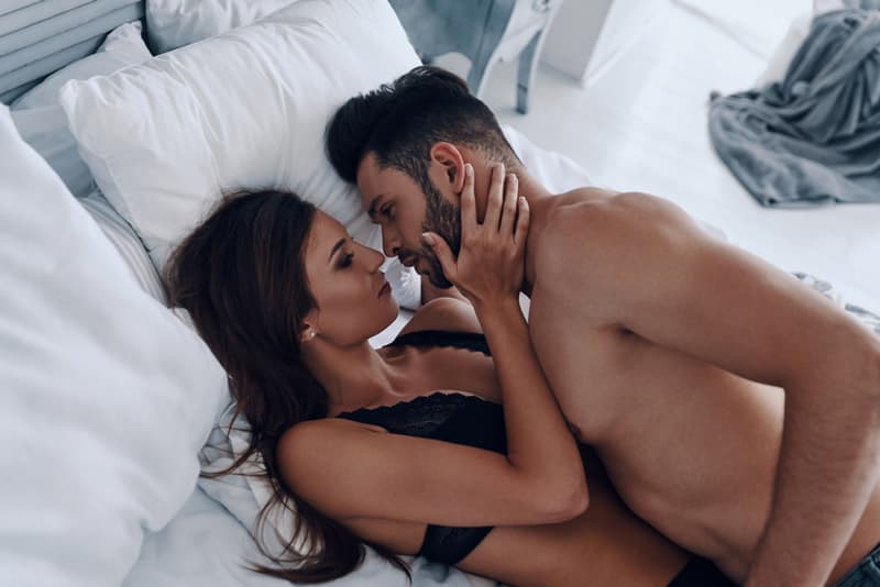 A man and a woman engaging in sexual activity in bed