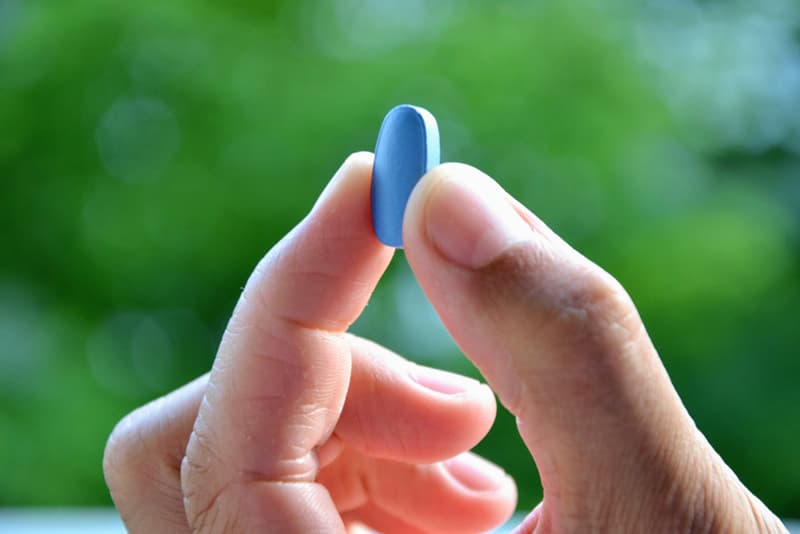 A hand holding up a Viagra pill