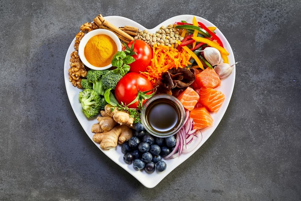A love heart shaped bowl filled with fruits and vegetables