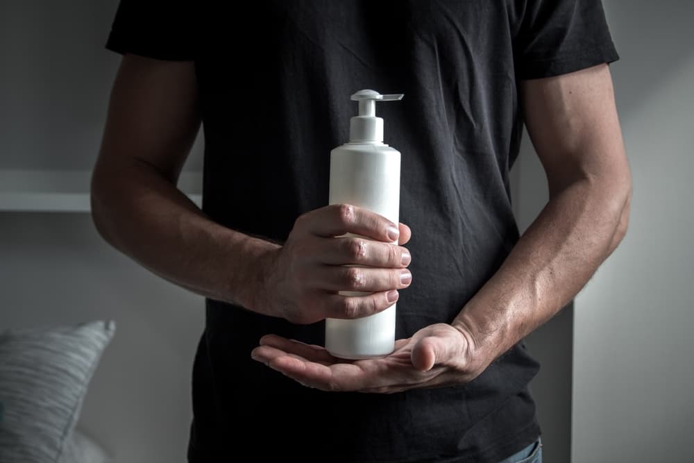 A man holding a tube of alprostadil cream