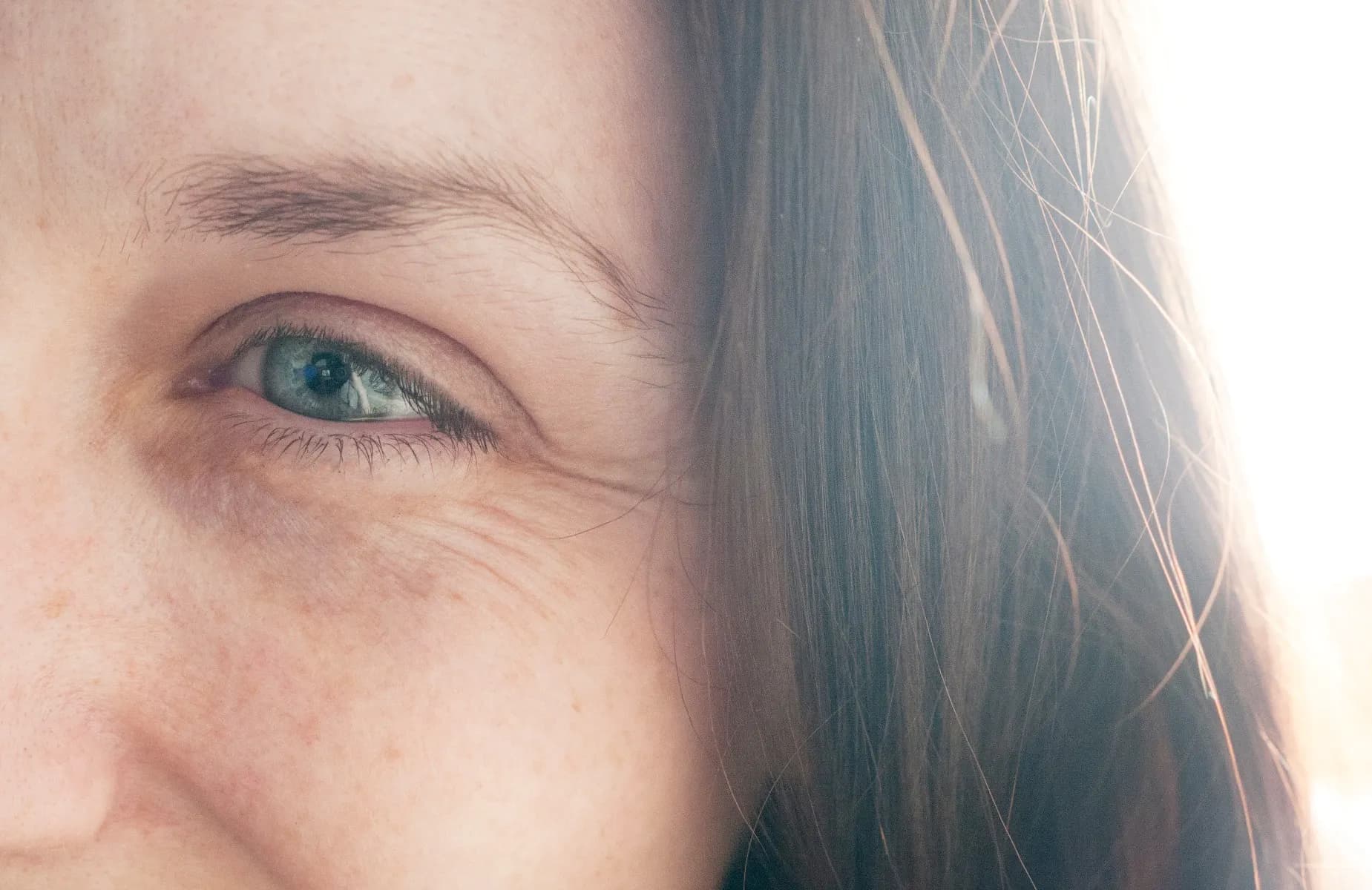 The corner of a lady's face. She has clear skin