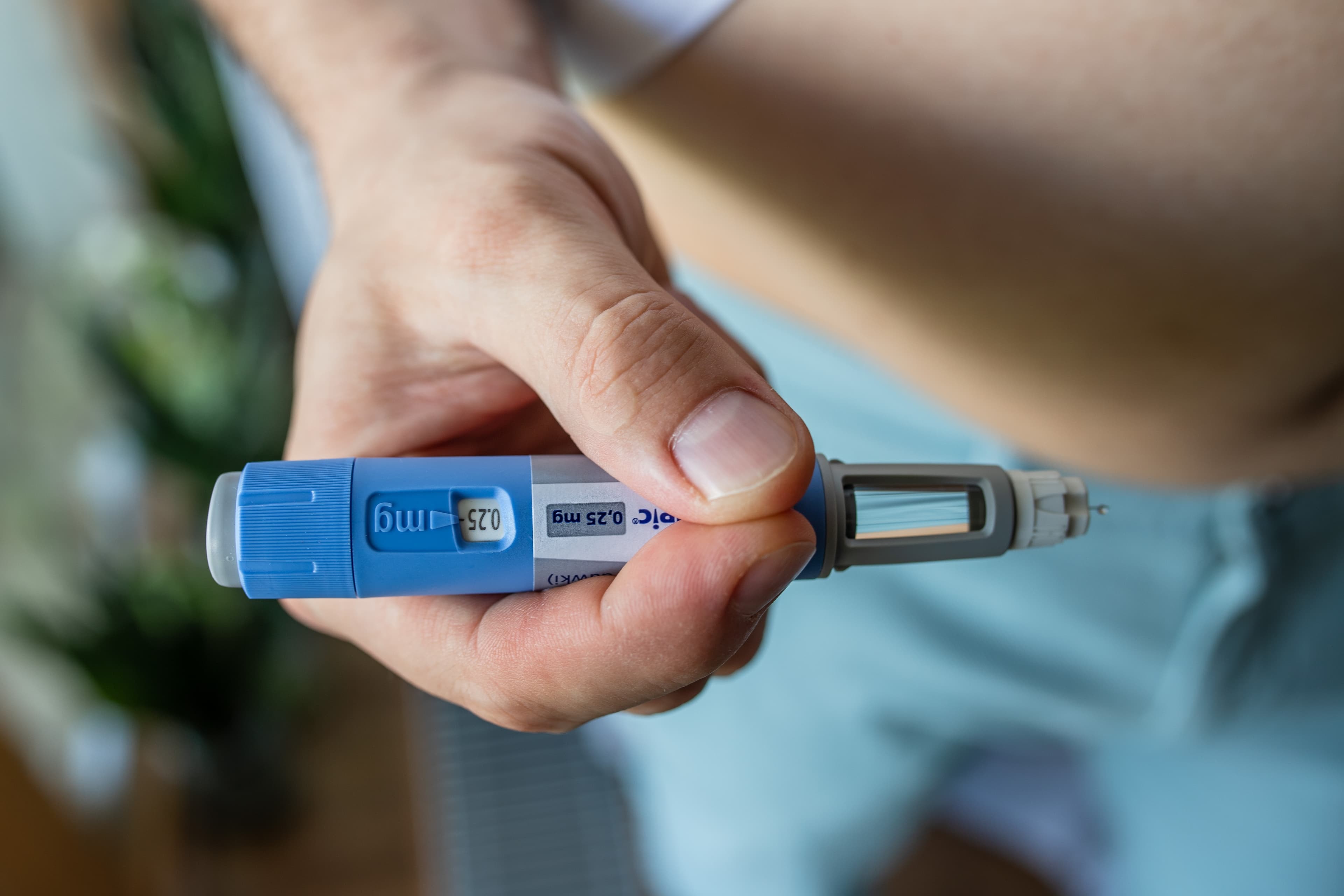 A weight loss injection being self administered into an overweight person's stomach