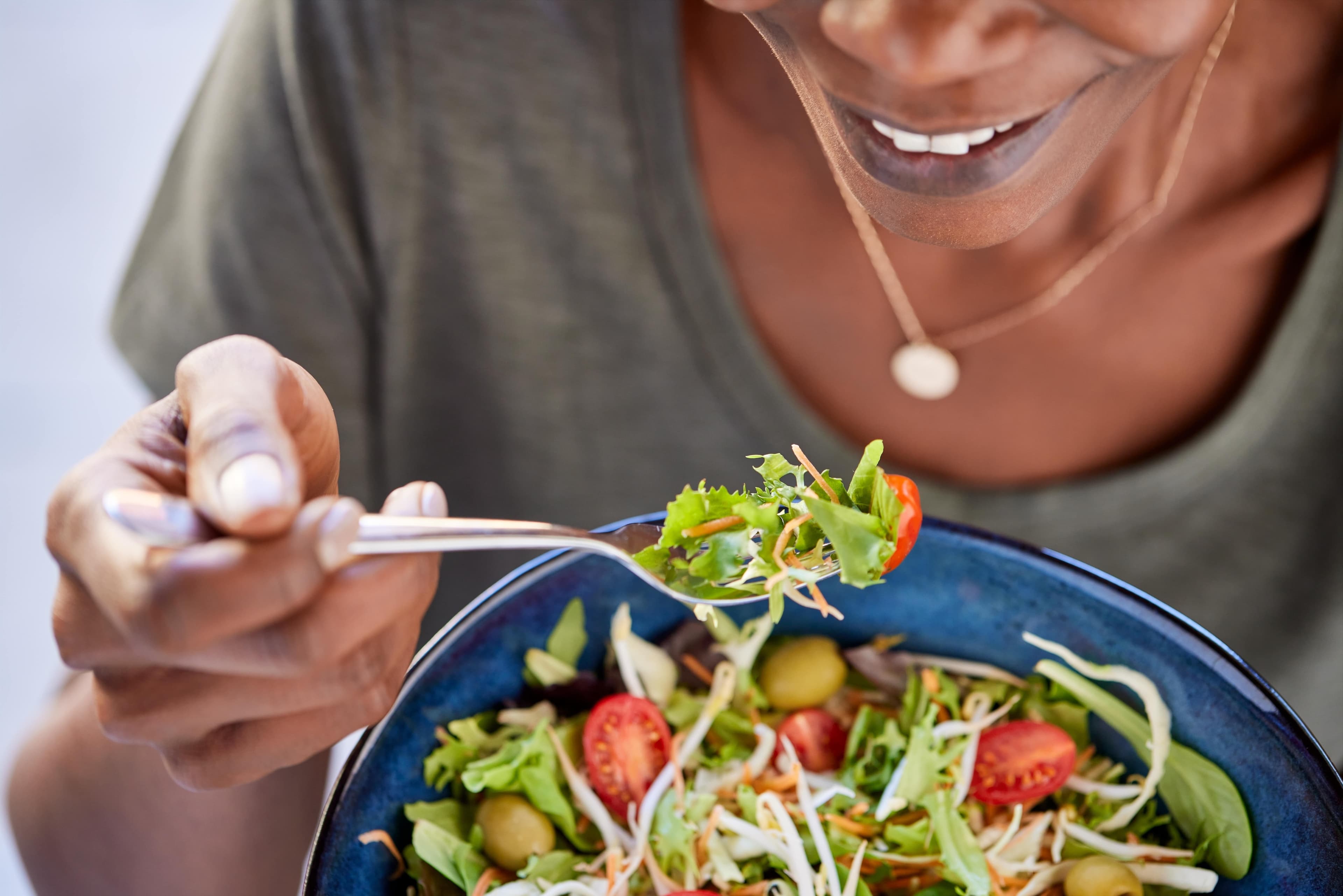 A lady eating a healthy bowl of salad