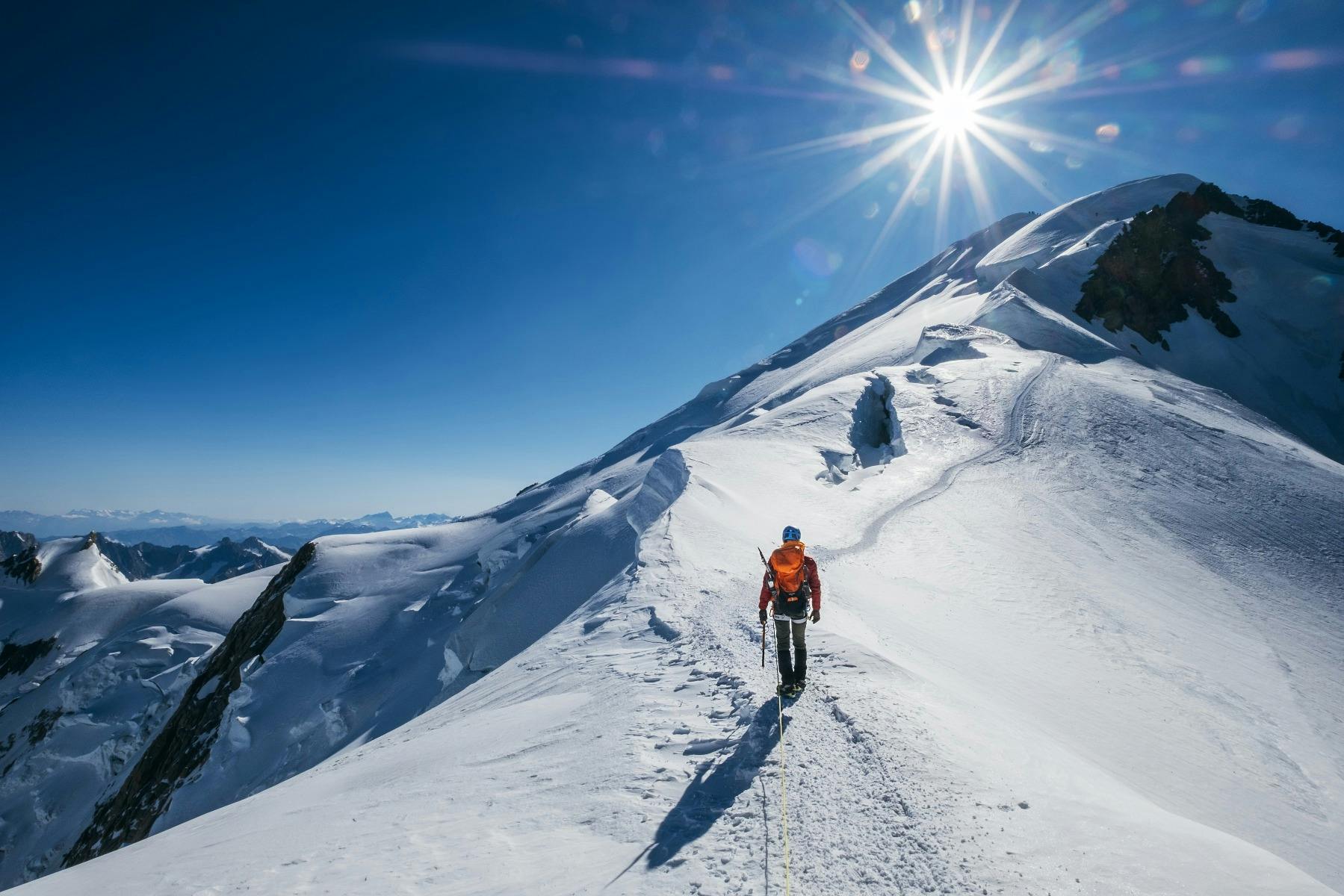 Man walking up a snowy mountain.