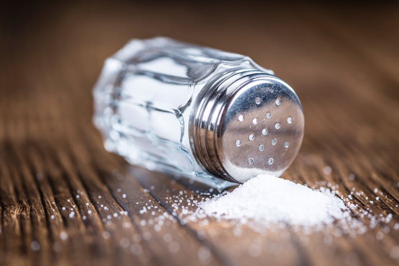 salt shaker spilled over a wooden floor