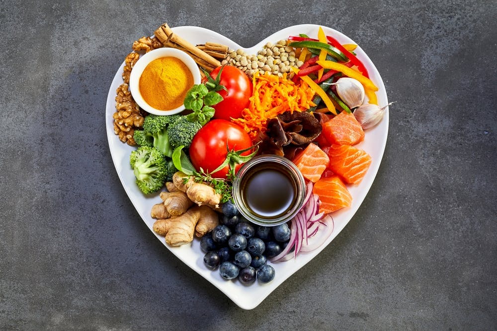 Various foods spread on a plate in the shape of a love heart
