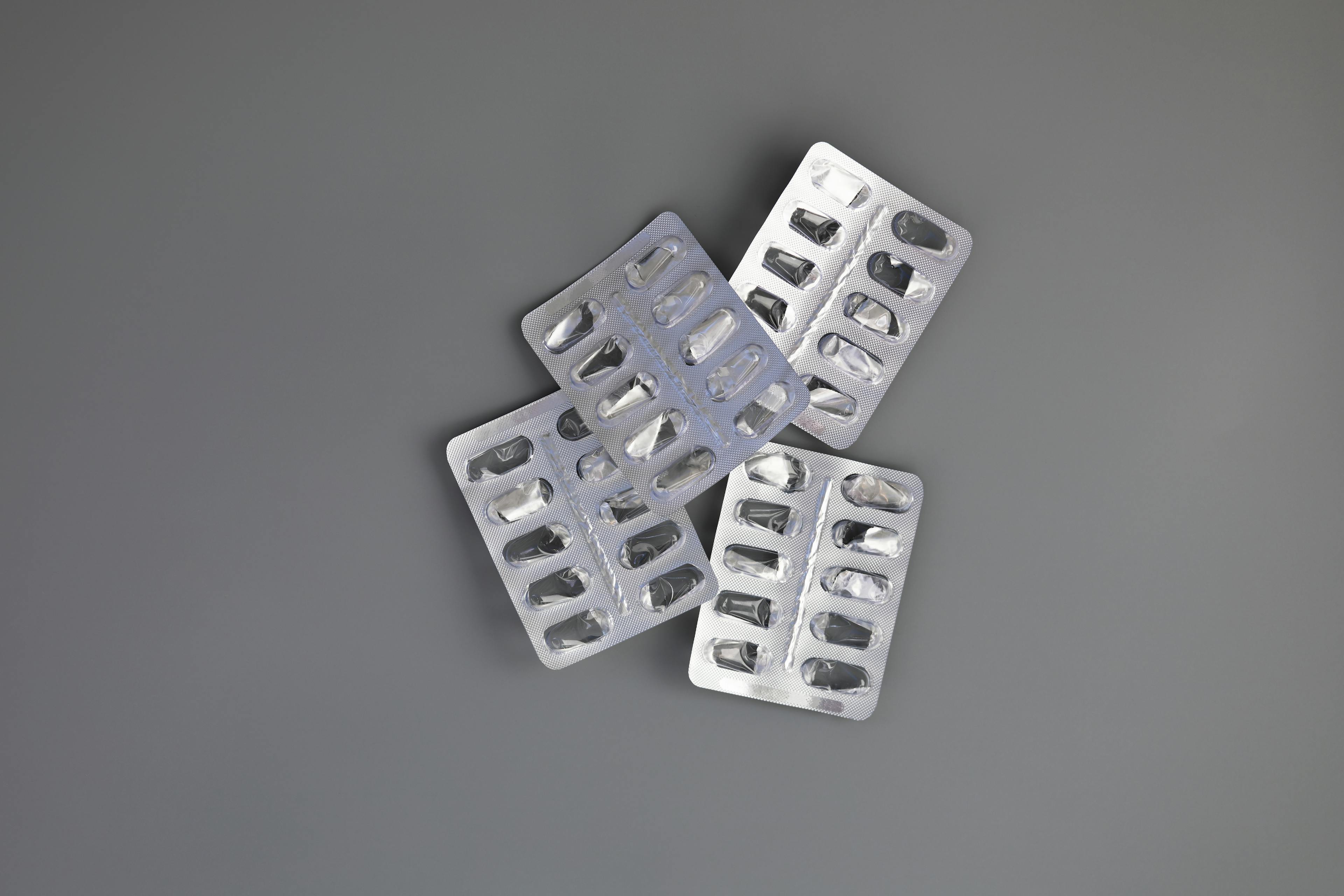 4 packets of medications laid flat on a grey surface