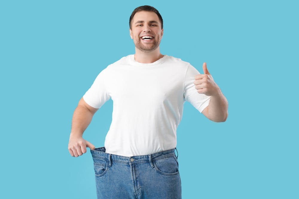 A man with loose trousers on because he has lost weight
